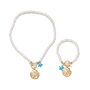 Detailed shot of ocean-themed jewelry set with pearls, golden shell, and blue starfish