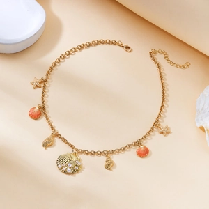 Close-up of golden ocean-themed necklace with starfish pendants and pearl shell details