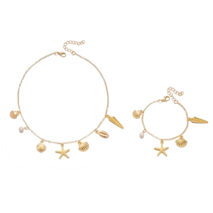 Detailed view of golden starfish and seashell charms on the jewelry set with white beads