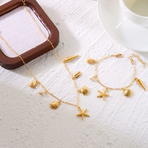 Detail of beach jewelry set featuring starfish and seashell charms with white pearls