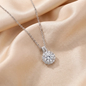 Close-up of a sparkling four-claw round diamond necklace on champagne silk background