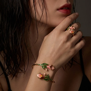 Detail van florale emaille sieradenset met calla lelie armband en ring op een model