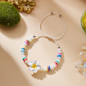 Close-up of colorful frangipani flower beaded bracelet with adjustable cord and sea decor