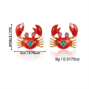 Detail of red crab earrings with blue heart crystal and measurements of 2cm by 2cm