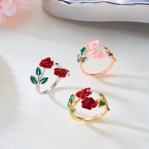 Drie elegante open rozenringen in goud, zilver en roségoud met groene bladeren