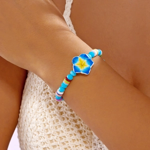 Close-up of a colorful beaded frangipani flower bracelet with blue and rainbow crystals