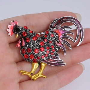 Vue détaillée de la broche coq faite main en émail noir avec des strass rouges