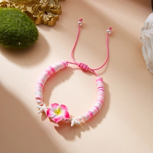 Detail of adjustable flower bracelet with pink plumeria, white starfish, and pearls