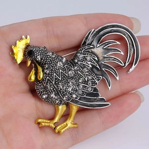 Détails d'une broche coq ornée de strass, émail noir et placage doré de haute qualité