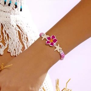 Macro view of bohemian flower bracelet with pink plumeria and starfish charms