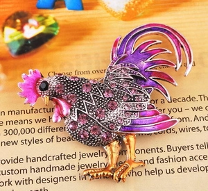 Gros plan détaillé d'une broche coq avec cristaux violets et artisanat en émail rose