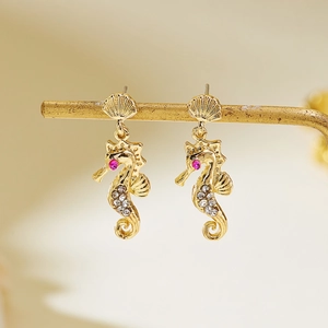 Detailed macro view of seahorse stud earrings with seashell tops and inlaid white zircons