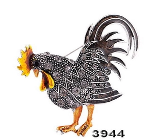 Détail d'une broche coq en alliage avec strass étincelants et laque orange faite à la main