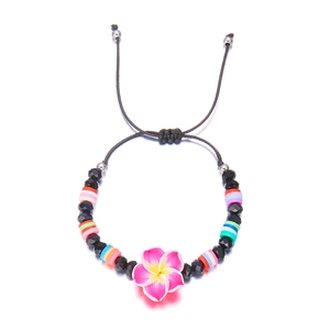 Detail of adjustable bohemian bracelet with pink plumeria flower and colorful clay beads