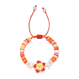 Detailed macro view of orange handmade beaded bracelet with plumeria and starfish accents