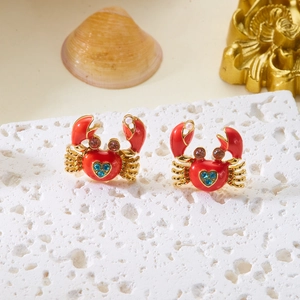 Detail of red crab stud earrings with blue heart crystal and small pearls on stone