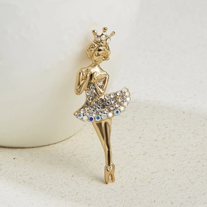 Macro view of crystal encrusted ballerina brooch with gold plating and rhinestones