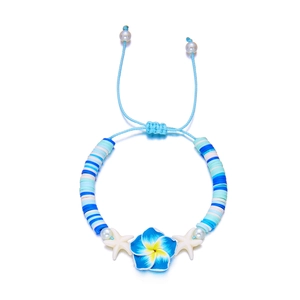 Detail of beach style bracelet with blue plumeria flower and white starfish charms