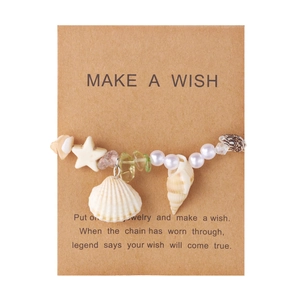 Detail von Seestern und Muschel Charms am Armband mit Make a Wish Karte
