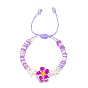 Close-up of handmade purple plumeria and starfish beaded bracelet with adjustable drawstring