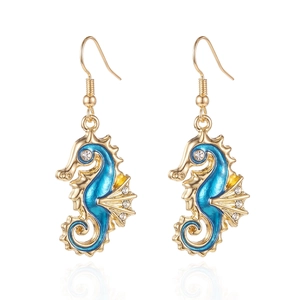 Macro detail of seahorse earrings with blue enamel, gold plating, and sparkling crystals
