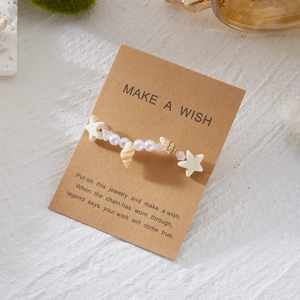 Detailaufnahme von Seestern- und Muschelperlenarmband auf Make A Wish Karte