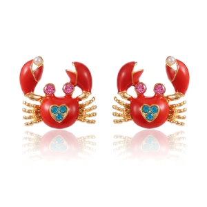Detail of red crab stud earrings with blue heart crystals and a small white pearl accent