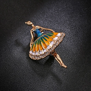Close-up of colorful enamel ballerina brooch with sparkling rhinestones on gold alloy