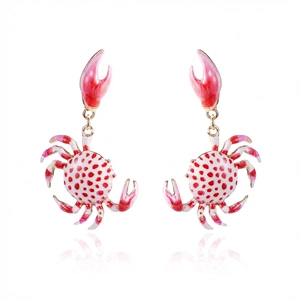 Detailed view of crab-shaped dangle earrings with white enamel and red polka dots pattern