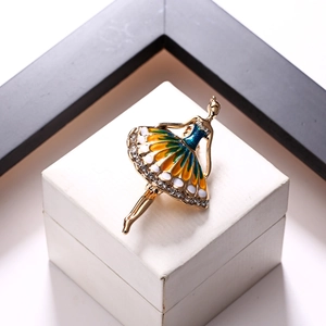 Detailed view of ballet girl brooch with colorful enamel dress and crystals on white box
