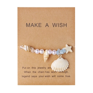 Detailansicht eines Seestern- und Muschelarmbands auf einer Make a Wish Geschenkkarte