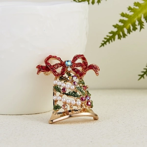 Detail der Weihnachtsglockenbrosche mit roten Steinen und grünem Emailleblatt