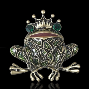Detailed close-up of a vintage gold frog brooch with green crystal eyes and enamel accents