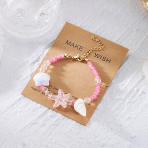 Böhmisches Ozean-Armband mit Seestern und Muscheln auf einer Kraftpapier-Geschenkkarte