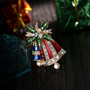 Weihnachtsglocken Brosche mit Emaille und Stechpalmenblättern auf Holzoberfläche