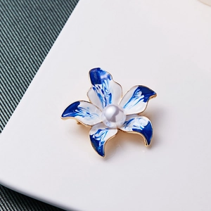 Detailaufnahme der blau-weißen Emaille-Blumenbrosche mit eleganter Perlenmitte