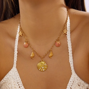 Gold-plated ocean shell necklace with starfish pendants and white pearl on model