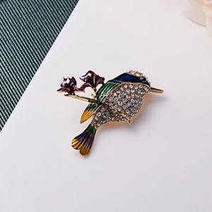 Makroaufnahme der Kolibri-Brosche mit buntem Emaille, Kristallen und Blumendetails