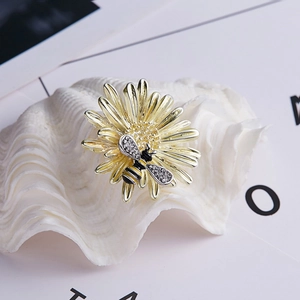 Sunflower bee brooch with yellow petals and sparkling crystal wings on a pearl shell
