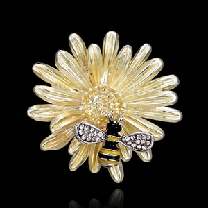 Detail of bee brooch with rhinestones on a yellow sunflower with a black reflective base