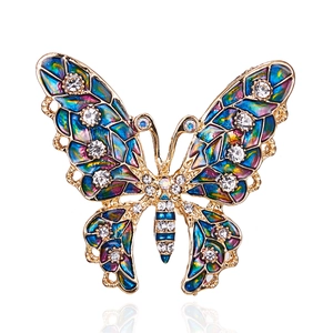 Detail view of gold butterfly brooch with colorful enamel wings and white rhinestones
