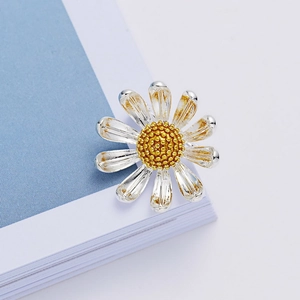 Broche marguerite à la mode plaquée argent et or sur fond minimaliste moderne