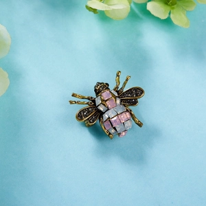 Macro shot of vintage bee brooch with colorful crystals and detailed black diamond wings