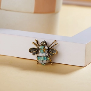 Detailed macro shot of vintage bee brooch with rhinestones and opal-like inlay stones