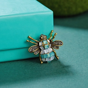 Macro shot of vintage bee brooch with blue rhinestones on a velvet jewelry box