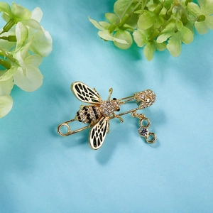 Détail de la broche abeille avec ailes en émail vert, strass et pendentif alvéole