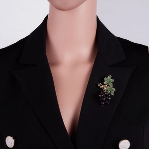 Vue détaillée de broche grappe de raisin perles violettes et cristaux sur costume noir