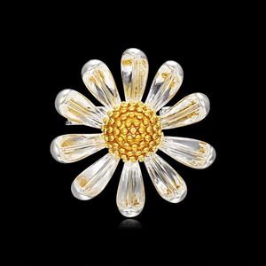 Élégante broche marguerite avec pétales argentés et centre doré texturé sur fond noir