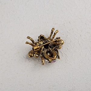 Close-up of vintage bee brooch back view with pin clasp and pink crystal detail