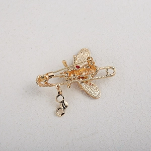 Détails de la broche abeille dorée avec pendentifs alvéoles et fermoir épingle de sûreté